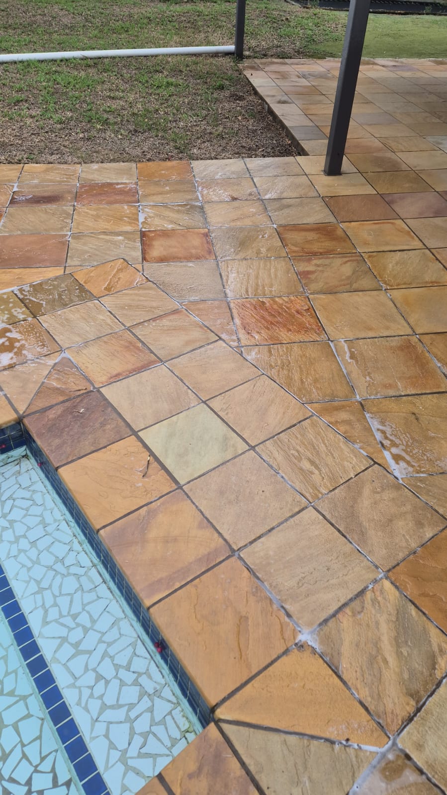 Garden patio after cleaning — golden stone tiles fully restored