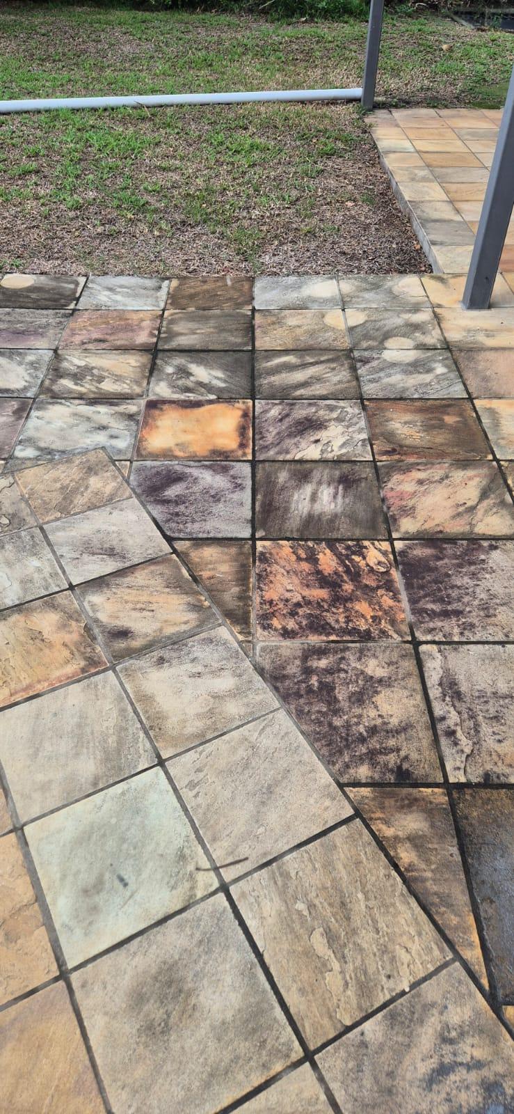 Garden patio before cleaning — dark mould and algae across tiles