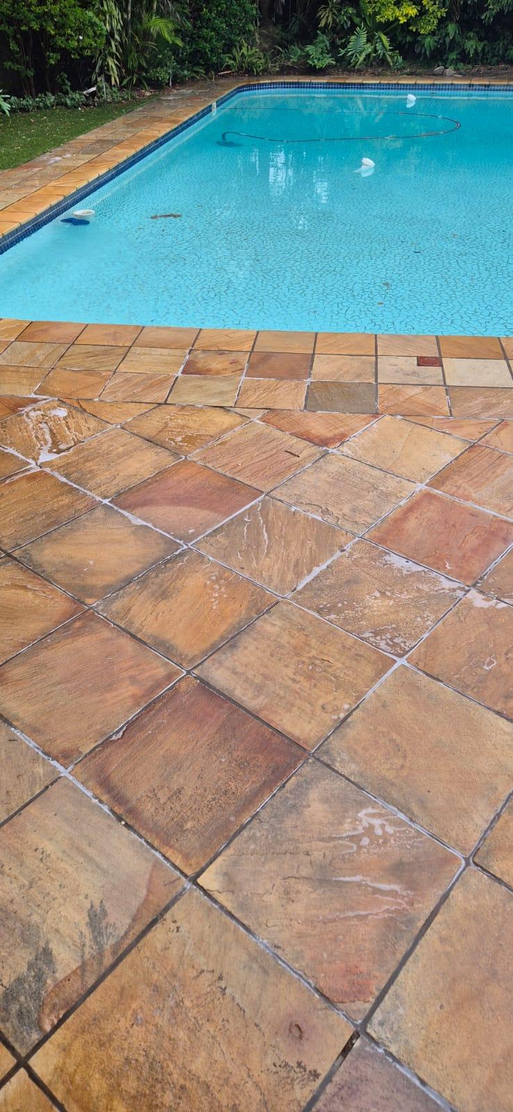 Pool deck after cleaning — clean stone tiles beside pool